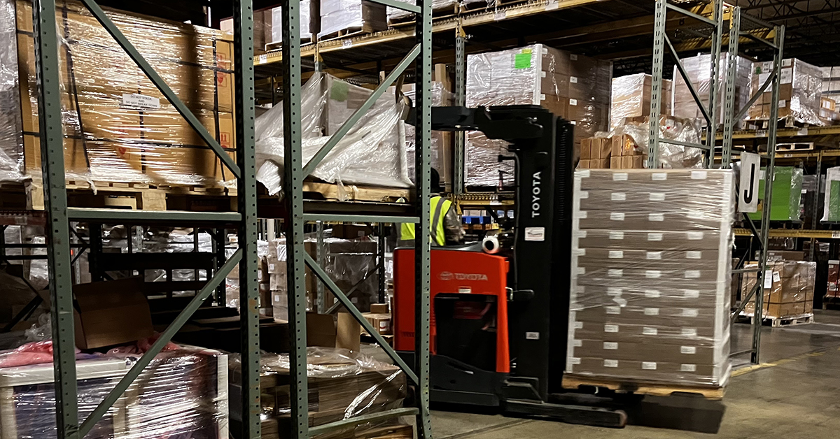 ASW warehouse in Akron, Ohio with towmotor carrying client product in wrapped boxes